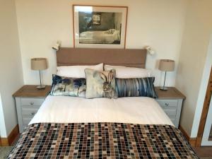 a bedroom with a bed with a rabbit pillow on it at Windyhill Cottage in Achiltibuie