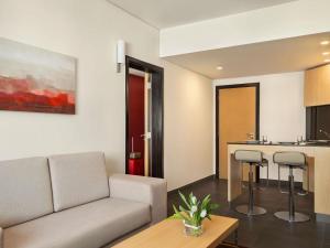 a living room with a couch and a kitchen at ibis Seef Manama in Manama +114 photos
