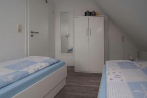 a bedroom with a bed and a white cabinet at Ferienhaus Lükko in Greetsiel