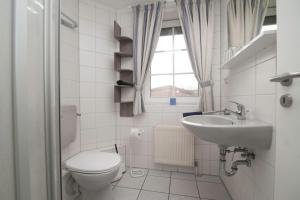 a bathroom with a toilet and a sink at Ferienhaus Lükko in Greetsiel +2 photos