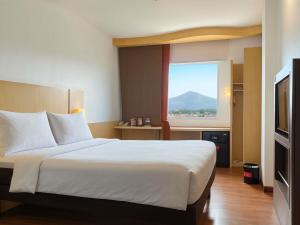 a hotel room with a bed and a window at Ibis Bandung Pasteur in Bandung