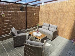 a patio with wicker chairs and a table at Apartmán BASARIJA in Hrabušice