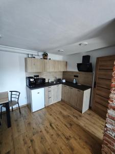 a kitchen with wooden cabinets and a table in a room at Apartmán BASARIJA in Hrabušice +5 photos