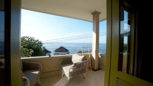 a balcony with chairs and a view of the ocean at Bayu - Ocean View - Boutique Hotel in Karangasem