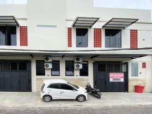 a white car parked in front of a building at Modern Stay near Roxy Mall Jember RedPartner in Panti