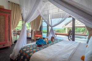 a bedroom with a bed with two teddy bears on it at Villa Bayu - exclusive villa with infinity pool, wellness pavilion, panoramic ocean view & full service in Temukus +36 photos