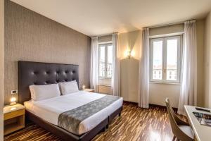 1 dormitorio con 1 cama grande y 2 ventanas en Albergo Firenze en Como