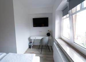 a bedroom with a desk and a tv on the wall at Double Room with Breakfast Free Parking and EV ready in Postojna