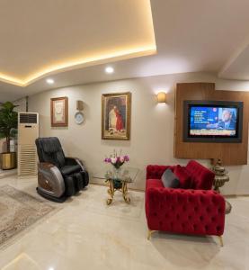a living room with a red couch and a tv at Efendi Hotel old town special category in Istanbul