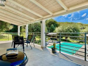 a patio with a table and chairs and a swimming pool at Elea Boutique Villa with private pool by DadoVillas in Acharavi