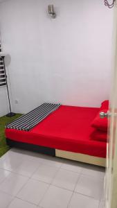 a red bed sitting in a room at MatiinJannah Homestay Arau in Arau