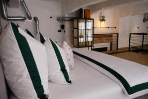 a bedroom with a bed with green and white pillows at Chaya Niwas Loft in Żyrardów