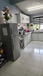 a kitchen with a refrigerator and a stove at MatiinJannah Homestay Arau in Arau +5 photos