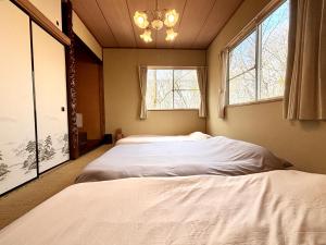 two beds in a room with two windows at SSK Mountain Base in Tsumagoi