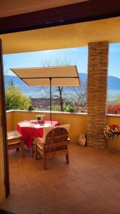 a table with a large umbrella on a patio at Dimora del falco in Montefalco