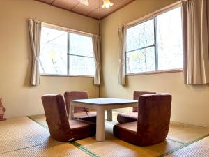 a table and chairs in a room with windows at SSK Mountain Base in Tsumagoi +42 photos