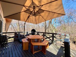 a wooden deck with a table and an umbrella at SSK Mountain Base in Tsumagoi