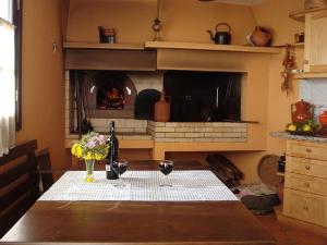 a table with two wine glasses and a fireplace at Palheiro Cavalinho in Prazeres