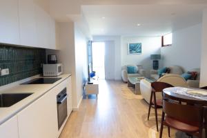 a kitchen and a living room with a table and a couch at Apartamento Saiáns in Oya