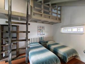 two twin beds in a room with two loft beds at Sandkasteel Self-Catering Accommodation in Vosburg