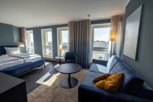 a hotel room with a couch and a bed at Michels Strandhotel Germania in Norderney +28 photos