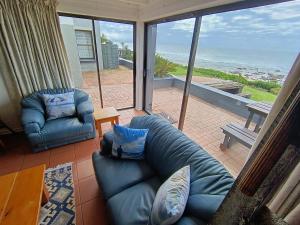 a living room with a couch and a chair at Sandkasteel Self-Catering Accommodation in Vosburg
