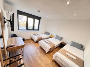 a room with three beds and a desk and a table at Auberge des Salles in Les Salles-sur-Verdon