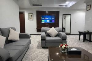 a living room with two couches and a tv at Carawan Al Khaleej Hotel Olaya in Riyadh