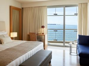 a hotel room with a bed and a view of the ocean at Daios Luxury Living in Thessaloniki +103 photos