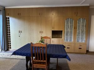 a dining room with a blue table and chairs and cabinets at Tranquility Town Stays in Winterton
