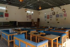 a dining room with wooden tables and blue chairs at The Jungle Walker Resort in Rishīkesh