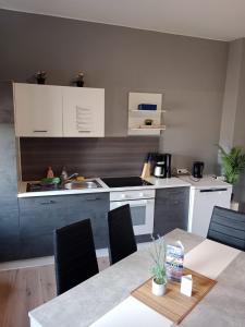 a kitchen with a table and a kitchen with white appliances at Flensburg City 6 1 in Flensburg