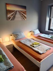 two beds in a room with a picture on the wall at Flensburg City 6 1 in Flensburg