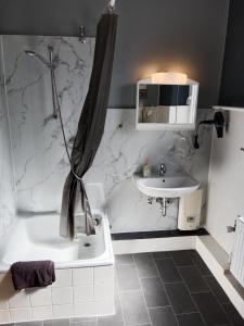 a white bathroom with a sink and a tub and a shower at Flensburg City 6 1 in Flensburg