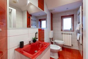 a bathroom with a red sink and a toilet at Schiller Apartment - Old Town in Sibiu