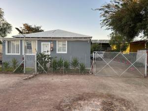 a house with a chain link fence in front of a house at Maltahöhe Self Catering in Maltahöhe