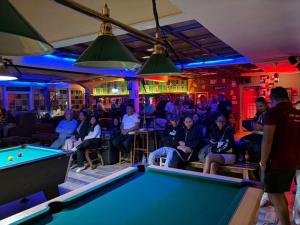 a group of people sitting in a bar with a pool table at Hotel VATOLA in Antsirabe