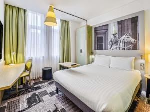 a hotel room with a bed and a desk at ibis Styles Glasgow Centre George Square in Glasgow +81 photos