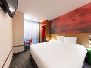 a hotel room with a large bed and a desk at ibis Styles Ambassador Seoul Myeong-dong in Seoul