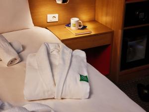 a hotel room with a white towel on a bed at ibis Styles Ambassador Seoul Myeong-dong in Seoul +56 photos