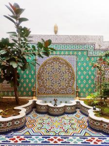 a room with a fountain and a wall with a tile floor at Riad Benkirane Fes Medina in Fez