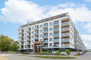 a large white building on a city street at Your Holidays Bel Mare Aqua F109 in Międzyzdroje