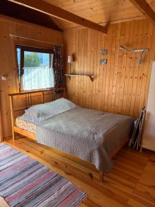 a bedroom with a bed in a wooden room at U Franka in Jastarnia