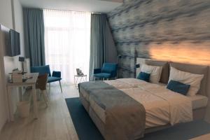 a bedroom with a large bed and a table and chairs at Hotel Haus am See in Lembruch +76 photos