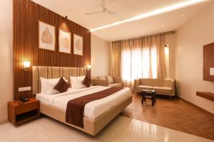 a hotel room with a large bed and a chair at HOTEL NARMADA RESIDENCY in Maheshwar +23 photos