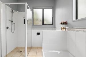 a white bathroom with a shower and a sink at Lime Tree Lodge in Wanaka +32 photos