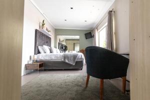 a bedroom with a bed and a chair in it at Luxury Suites on Santorini in East London