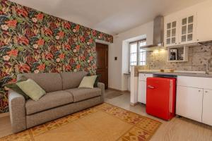 a living room with a couch and a red refrigerator at Maison Orange - Dimora nelle Langhe in Neive