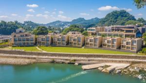 a row of apartment buildings next to a river at Jim Corbett Marriott Resort & Spa in Rāmnagar