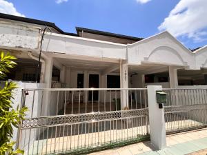 a white house with a white fence at Aznah’s Stay in Kuching